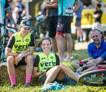 A photo of four Reef 2 Reef riders, relaxing on the grass next to their bikes