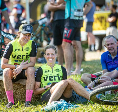 A photo of four Reef 2 Reef riders, relaxing on the grass next to their bikes